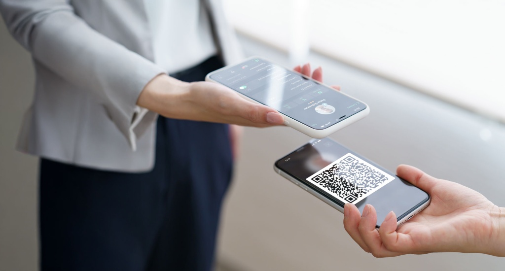 Smartphone scans QR code for Threema contact verification.