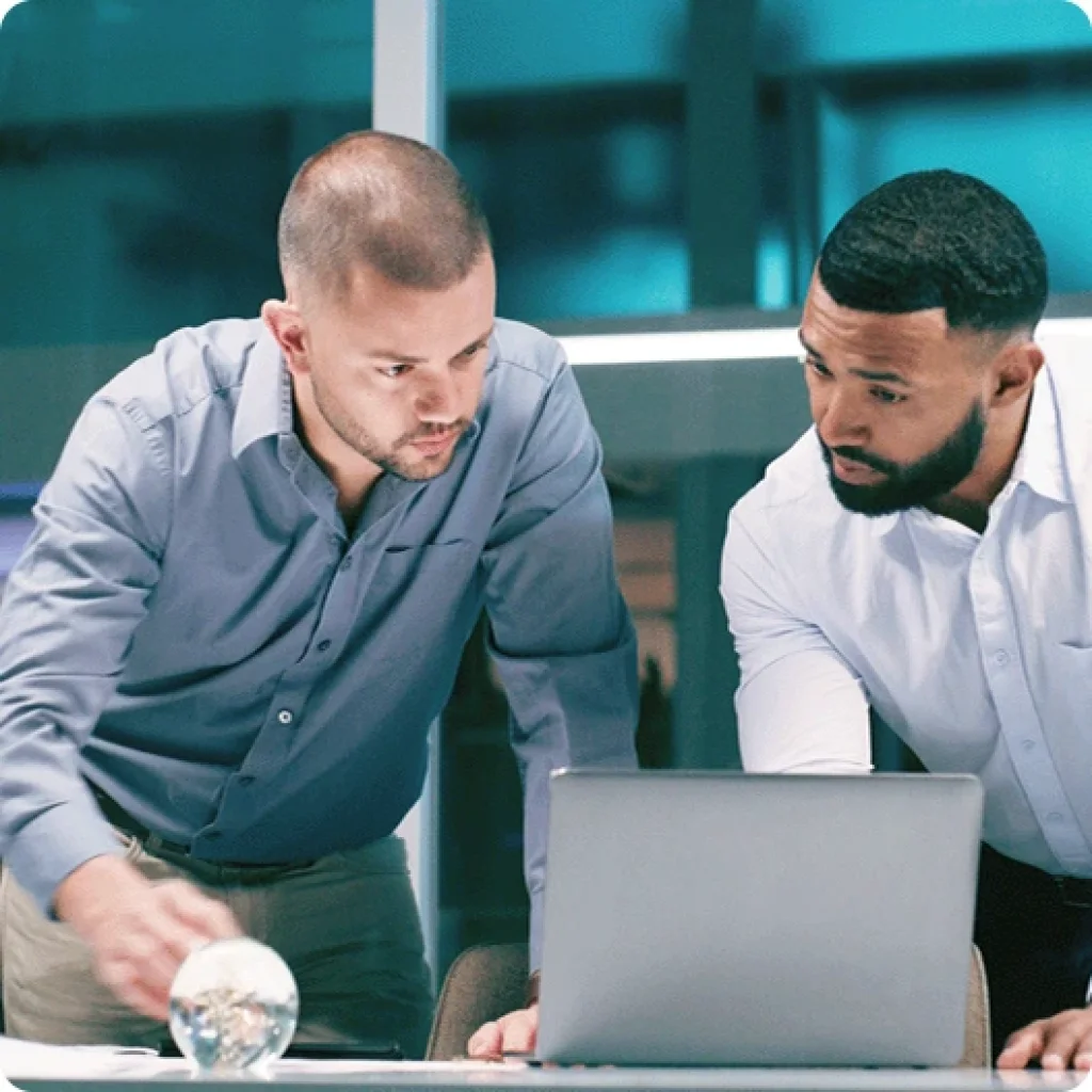 Two people working at laptop – symbolized teamwork.