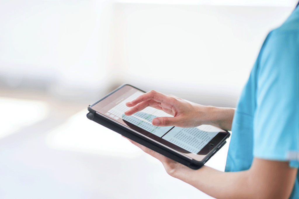Person in medical clothing using a tablet computer in a sterile environment.