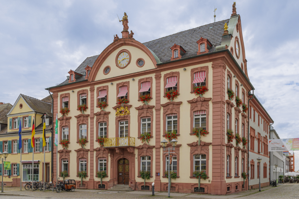Ayuntamiento hist&oacute;rico de Offenburg con fachada barroca y flores.
