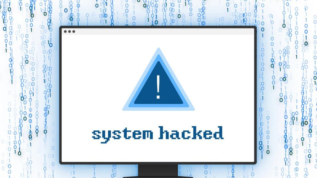 Monitor showing a white window with a blue warning triangle and 'system hacked' on binary code background.