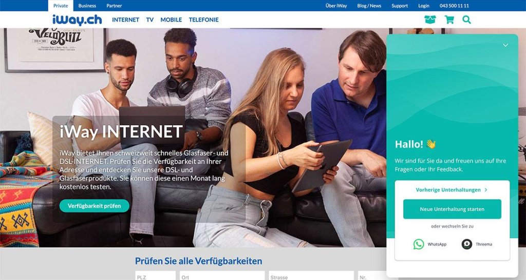 Vier Personen auf einer Couch mit Laptop und Tablet, die Internetverbindung veranschaulichen.