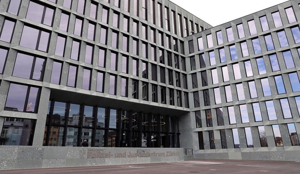 Fa&ccedil;ade moderne en pierre grise avec grille de fen&ecirc;tres r&eacute;fl&eacute;chissantes.