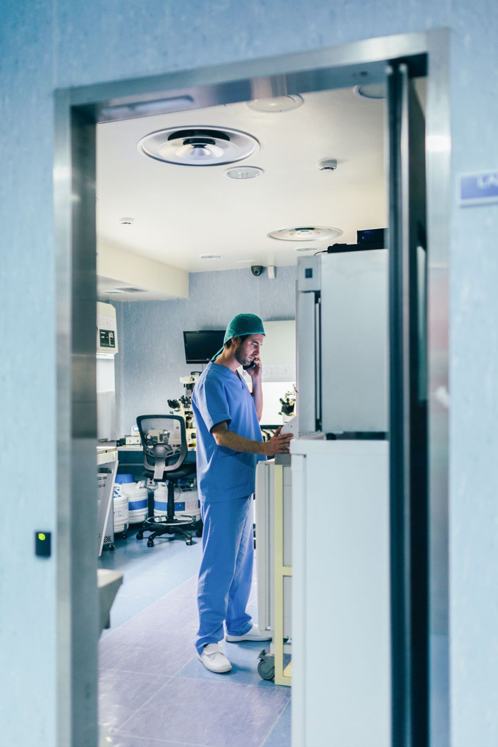 Physician callig on his smartphone in a hospital in medical clothing.